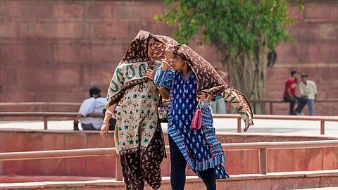 omen cover themselves on a hot summer day, at Red Fort, in New Delhi, Tuesday, May 19, 2026.