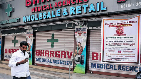 A man walks past a closed medical shop in Hyderabad.