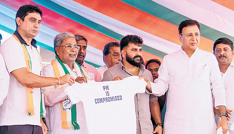 CM Siddaramaiah, AICC General Secretary Randeep Singh Surjewala and others hold a T-shirt that reads ‘PM Is Compromised’ during the protest led by Youth Congress members over the NEET exam paper leak, in Bengaluru on Thursday.