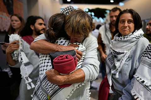 Activists from the Global Sumud Flotilla comfort each other upon their arrival at Istanbul Airport, in Istanbul, Turkey, Thursday, May 21, 2026.