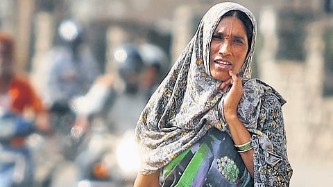 A woman, covered in a scarf, walks along a road in Hyderabad on Friday.