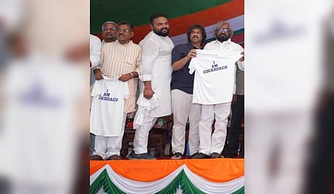 Congress leaders, including ministers Eshwar Khandre and Madhu Bangarappa, distribute ‘I’m a cockroach’ T-shirts.