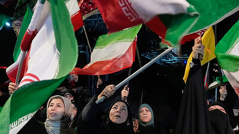 Pro-government demonstrators wave Iranian flags during their gathering at a square in downtown Tehran, Iran, Tuesday, May 19, 2026.