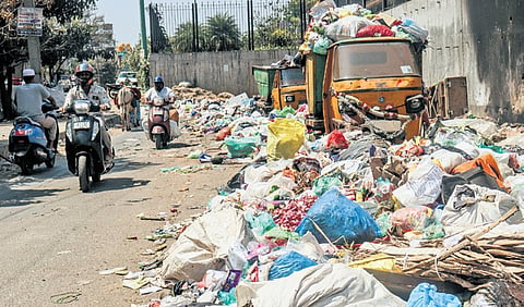 Heaps of garbage piled up along a road in Kumarswamy Layout.