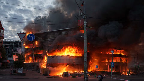 A man carries a box from a burning trade center after a Russian strike on Kyiv, Ukraine, on Sunday, May 24, 2026.