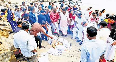Residents of Munambam burn copies of their property document to protest the delay in restoration of their revenue rights
