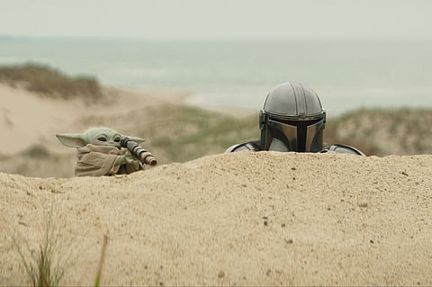 This image released by Disney shows The Mandalorian, portrayed by Pedro Pascal, right, and Grogu in a scene from Lucasfilm's "Star Wars: The Mandalorian and Grogu.