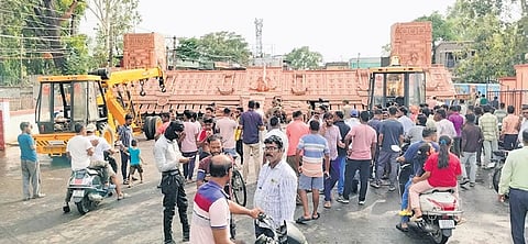 People gather near the collapsed structure at Thana chowk in Bargarh town.