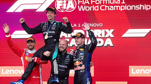 Mercedes driver Kimi Antonelli (top) of Italy is hoisted by second-place Ferrari driver Lewis Hamilton (left) of Britain and Mercedes team senior composite technician Dean Hale (second from right), and third-place Red Bull Racing driver Max Verstappen (right) of the Netherlands, as he wins the F1 Canadian Grand Prix auto race in Montreal, on May 24, 2026.