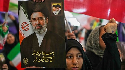 A woman holds a portrait of Iran's Supreme Leader, Ayatollah Mojtaba Khamenei, during a ceremony honoring the armed forces and those killed in the war with Israel and the U.S. at the Imam Khomeini Grand Mosque in Tehran, Iran, Sunday, May 24, 2026.