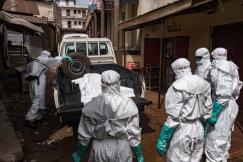 Workers from the Uganda Red Cross Society spray disinfectant during the evacuation of the body of a suspected Ebola victim in Kampala on May 26, 2026.