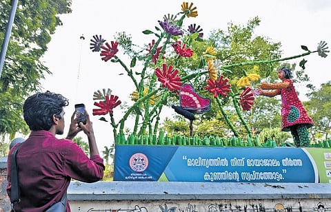A youth takes photo of an art installation at Kanakakkunnu Palace