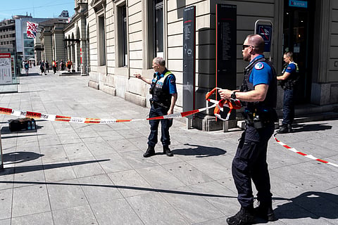 Police officers remove tape following a stabbing attack at the train station in Winterthur, Switzerland
