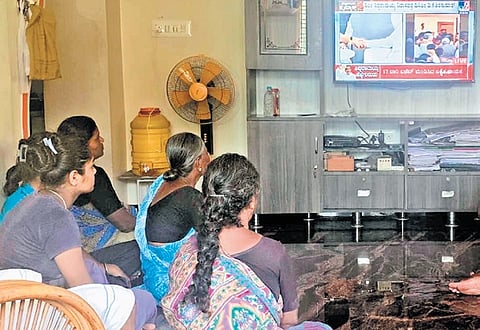 Villagers watch CM Siddaramaiah’s press conference on TV at his village Siddaramanahundi in Mysuru on Thursday