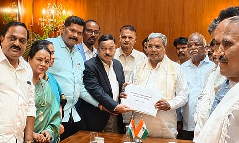 Chairman of the Backward Classes Commission, Madhusudan Nayak, submits the social and educational survey report to CM Siddaramaiah.