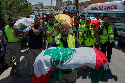 A paramedic volunteer carries a body, one of the six the family members who were killed on Wednesday when their car was struck in an Israeli airstrike on a highway as they fled their village, during a funeral procession in the southern port city of Tyre, Lebanon, Friday, May 29, 2026.