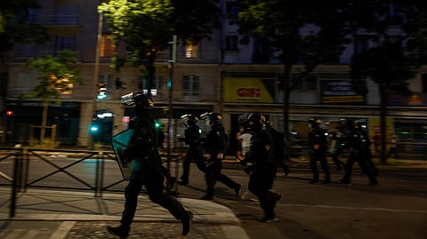 French Republican Security Corps (CRS - Compagnies Republicaines de Securite) Police officers run on a street to disperse PSG supporters during celebrations following their team's win in the UEFA Champions League final between PSG and Arsenal FC played in Budapest, in Paris on may 30, 2026.