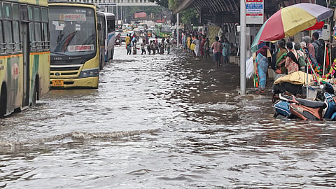 People wade through waterlogged busy East Fort in Thiruvananthapuram on Saturday after heavy rainfall on Saturday,disrupting traffic and daily life.