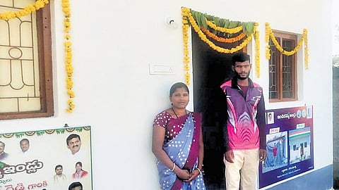 Siddam Muthu and his wife, who belong to Kolam tribe, stand in front of newly allotted Indiramma house on Monday