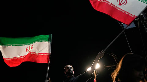 Demonstrators wave Iranian flags during a pro-government gathering at Islamic Revolution Square in Tehran, Iran, Saturday, May 30, 2026.