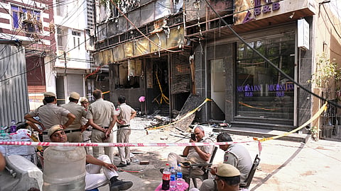 Police personnel keep a vigil at the spot a day after a fire at the Flourish Stay B&B killed at least 21 people, including 12 foreigners, at Hauz Rani area of Malviya Nagar, in New Delhi, Thursday, June 4, 2026.