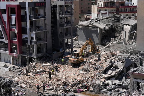 Rescue workers use an excavator, as they search for victims under the rubble of a building that was hit Monday in an Israeli airstrike in the southern port city of Tyre, Lebanon, Tuesday, June 2, 2026.
