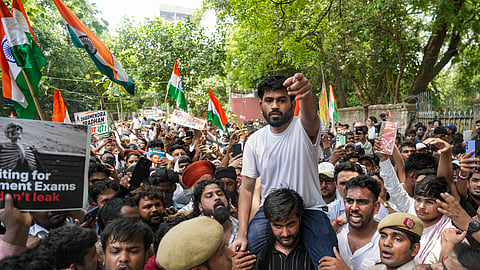 A supporter carries the Cockroach Janta Party (CJP) founder Abhijeet Dipke, in white, over his shoulder during a protest demanding the resignation of Union Education Minister Dharmendra Pradhan over alleged examination-related lapses, at the Jantar Mantar, in New Delhi, Saturday, June 6, 2026.