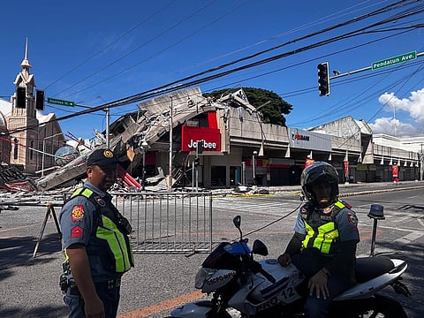 Police gather in front of a collapsed Jollibee fast food restaurant after an 7.8 magnitude earthquake in General Santos City on June 8, 2026.