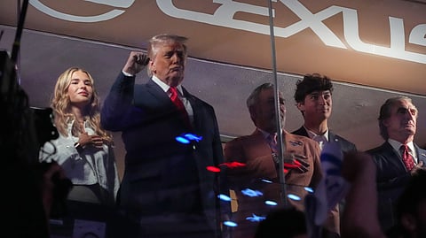 President Donald Trump gestures during the National Anthem as he attends an NBA Finals playoff basketball game between the New York Knicks and the San Antonio Spurs at Madison Square Garden in New York, Monday, June 8, 2026, with Kai Trump, left, Knicks owner James Dolan and Interior Secretary Doug Burgum, right.