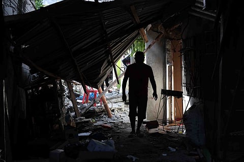 A resident walks past debris from damaged houses following an earthquake in General Santos, Philippines Tuesday, June 9, 2026