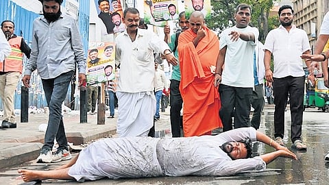 A supporter of CM DK Shivakumar performs urulu seve from Anand Rao Circle to Annamma Devi Temple in Bengaluru on Tuesday.