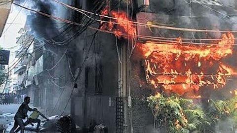 Local people attempt to douse a fire at a hotel in New Delhi, India, Wednesday, June 3, 2026
