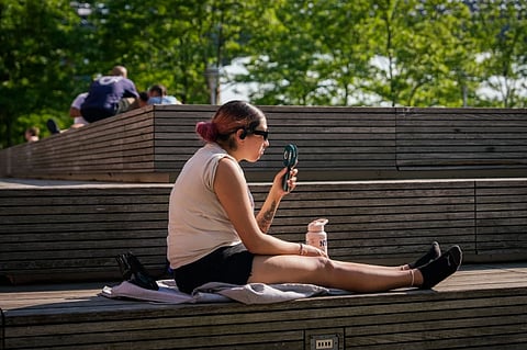 A person uses a fan during a heat advisory in the Brooklyn borough of New York, May 19, 2026.