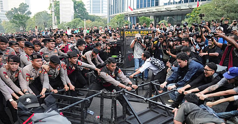 Student protesters tear down a police barricade during a rally against a fuel price hike, government inefficient spendings, and military involvement in civilian affairs in Jakarta, Indonesia, Friday, June 12, 2026.
