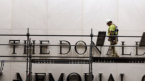 Workers prepare to remove Trump's name from the Kennedy Center