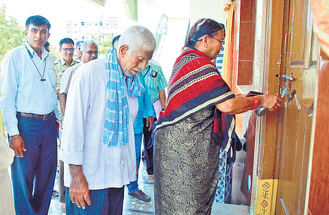 After their son was evicted on the order of the district collector, Enzam Ramana Reddy and Chandrakala open the front door of their residence at Housing Board in Miryalaguda, Nalgonda district, on Sunday