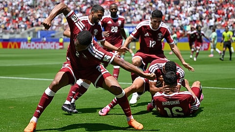 Qatar's Boualem Khoukhi is mobbed by teammates after scoring his sides first goal during the World Cup Group B soccer match between Qatar and Switzerland on Saturday, June 13, 2026.