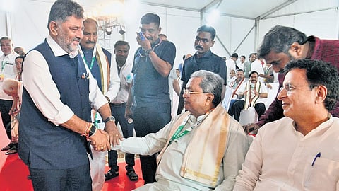 CM DK Shivakumar greets former CM Siddaramaiah at the CLP meeting in Bengaluru on Tuesday. AICC General Secretary Randeep Singh Surjewala looks on