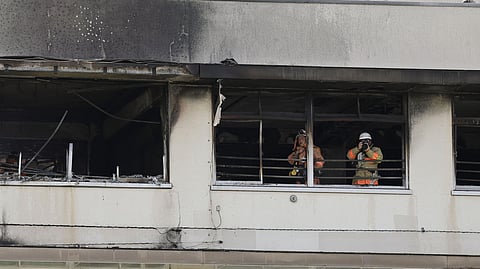 Firefighters work at the site of a fire at an elementary school in Tokyo, Friday, June 19, 2026.