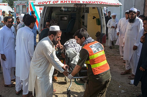 Volunteers transfer the body of a victim, killed in twin roadside blasts, to a hospital in Bannu on June 20, 2026.