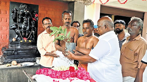 K Rajasethumurali hands over a sapling to a grieving family after a funeral at the Aathupalam crematorium in Coimbatore.