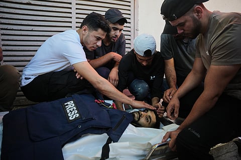Palestinians mourn over the body of Al Jazeera cameraman Ahmed Wishah, who was killed in an Israeli airstrike, during his funeral at Al-Aqsa Hospital in Deir al-Balah, central Gaza Strip, Sunday, June 21, 2026.