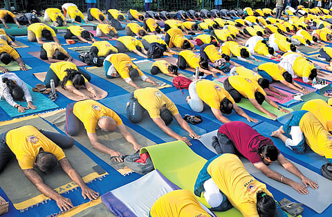 People participate in a yoga session in front of Vidhana Soudha on the International Yoga Day on Sunday;