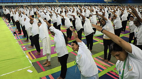 Yoga enthusiasts participate in a mass meditation session during the International Day of Yoga celebrations at Jimmy George Indoor Stadium on Sunday.