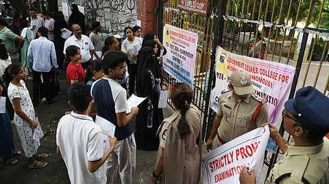 Students appearing for the NEET entrance exam wait outside the centre in Begumpet.