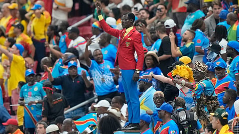 Congo supporter Michel Nkuka Mboladinga poses as a statue of the country's assassinated independence hero Patrice Lumumba ahead of the World Cup Group K soccer match between Colombia and Congo on Tuesday, June 23, 2026.
