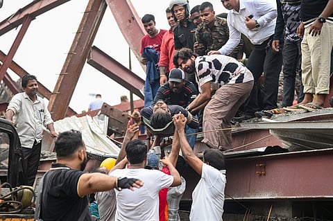 An injured person being assisted after a three-storey under-construction warehouse collapsed in the Taratala area, in Kolkata, West Bengal, Wednesday, June 24, 2026. A Kolkata Police official said 10 people have so far been rescued and taken to the nearest hospital.
