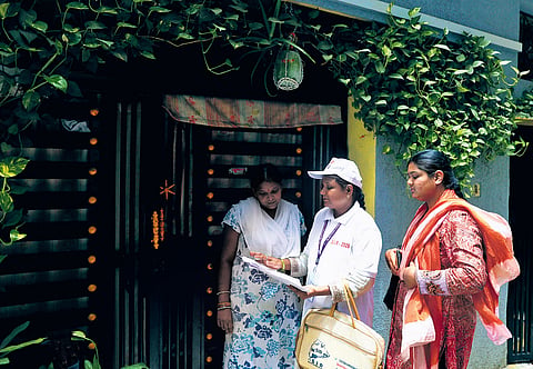A booth level officer distributes enumeration forms to residents at Banjara Hills in Hyderabad on Thursday.