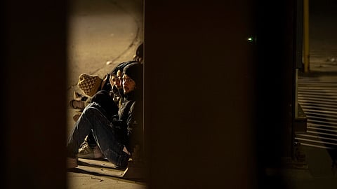 A group of migrants wait to be processed between two border walls separating Mexico and the United States after crossing illegally before dawn, Jan. 21, 2025, in San Diego.
