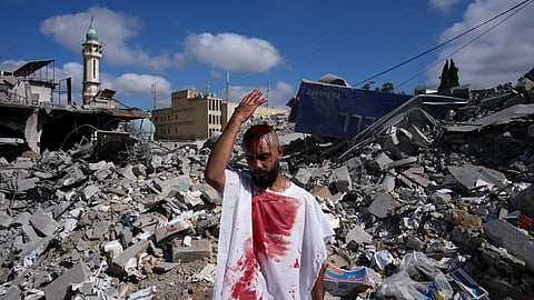 A man bleeds from a ceremonial head wound as he strikes his head during Ashoura, when Shiites commemorate the martyrdom of Imam Hussein, the grandson of the Prophet Muhammad, amid buildings destroyed by Israeli strikes in Nabatiyeh, southern Lebanon, Friday, June 26, 2026.